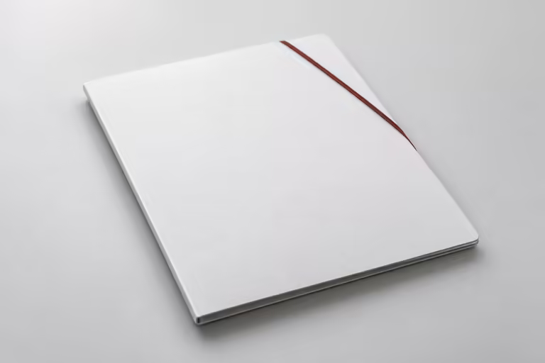 A closed white document folder lying flat on a grey surface, a thin dark red elastic band across one corner